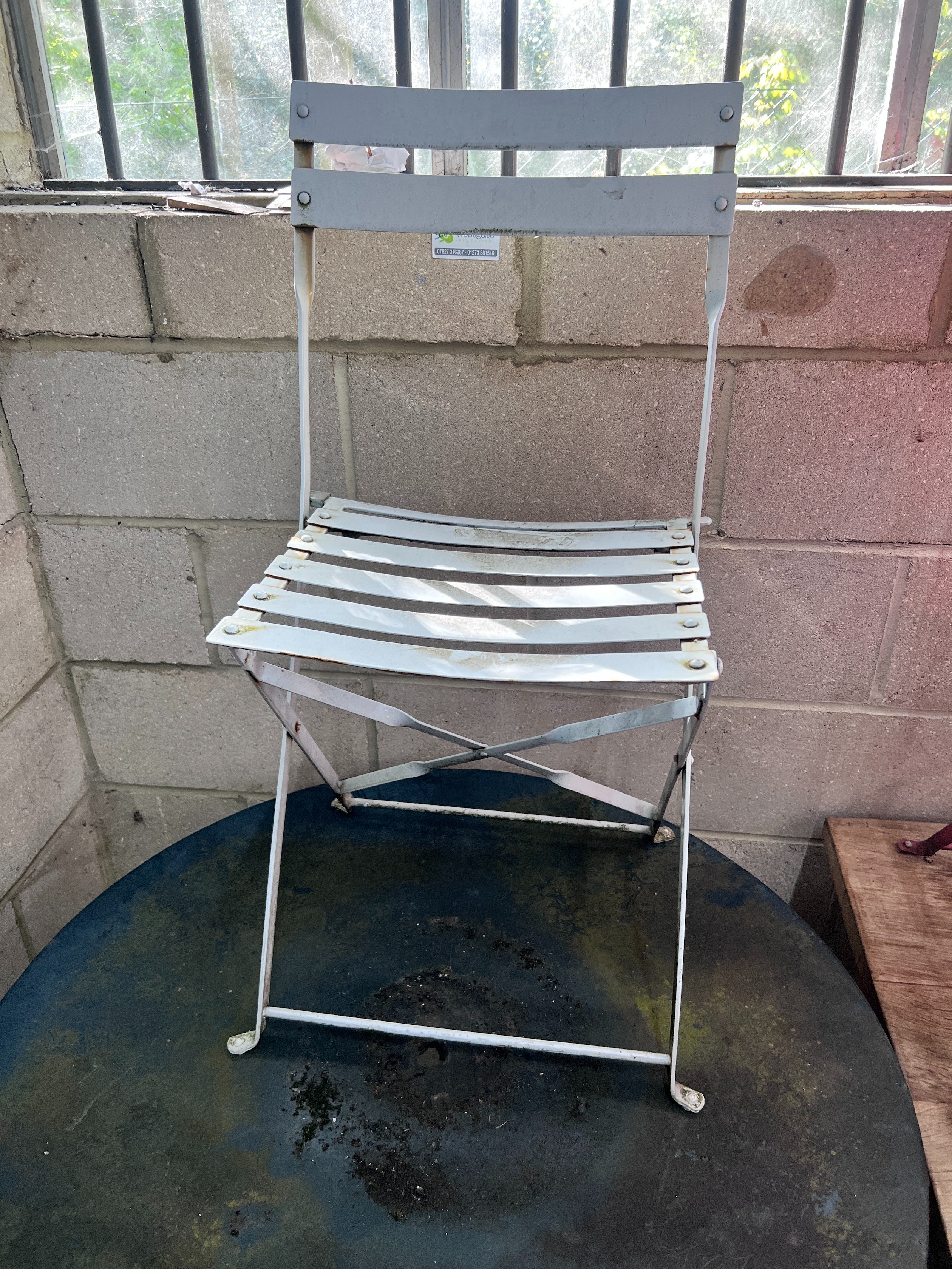 A circular metal and wrought iron garden table, diameter 90cm and three chairs *Please note the sale commences at 9am.
